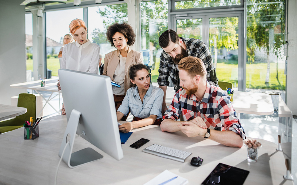 Young people start talking as a team while working in the corporate office.